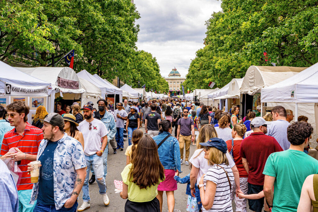 Raleigh, North Carolina USA-05 20 2023: A Large Crowd Enjoys Shopping for Paintings and Crafts at the Artsplosure Art Fair.