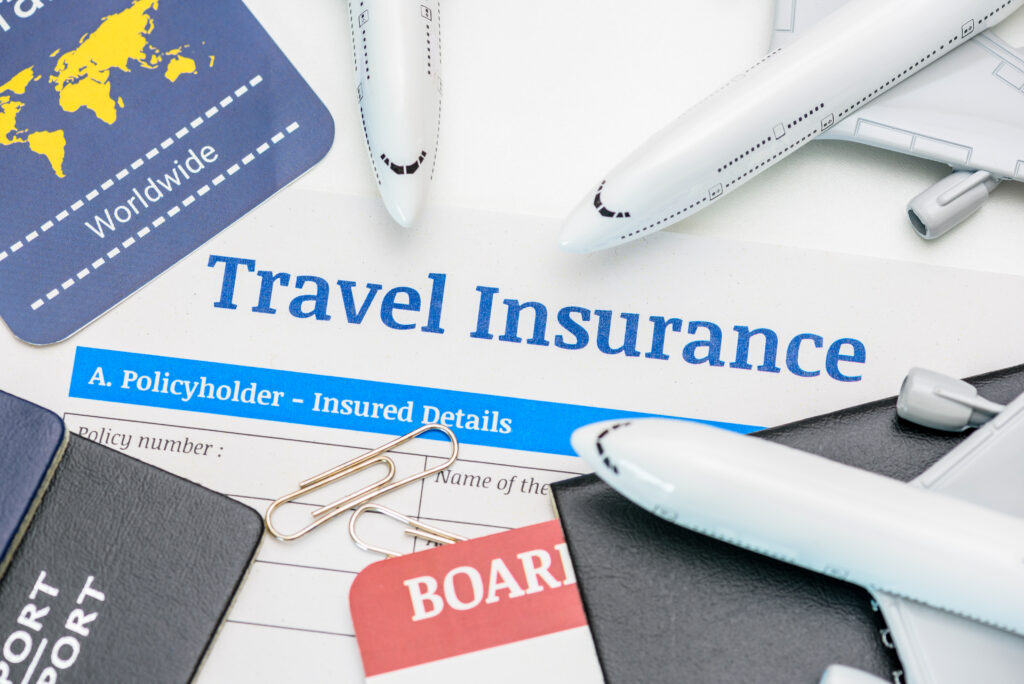 Travel insurance and service concept : Top view of travel insurance application form, a boarding pass, passport, airplanes. Travel insurance covers costs and losses associated with traveling.